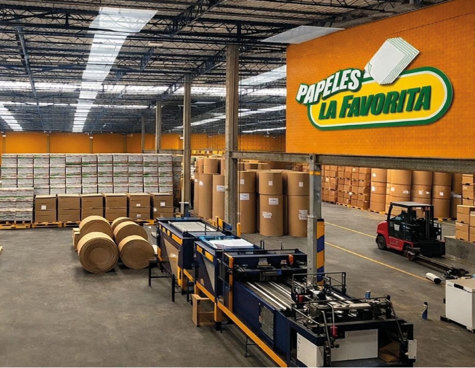 Bodega de COOPDECOC con rollos de papel y maquinaria industrial